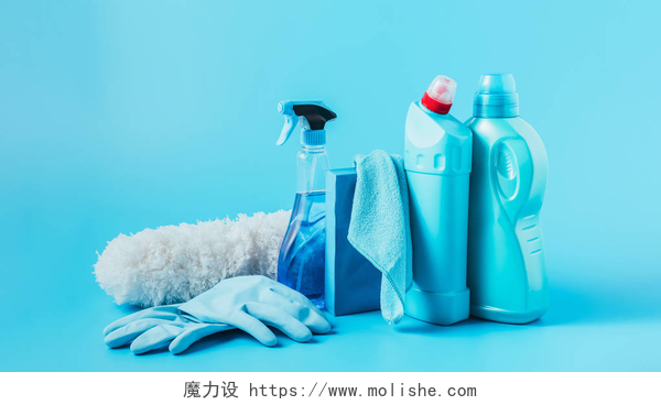 蓝色背景下的清洁工具在蓝色背景下关闭除尘器、橡胶手套、清洗液、洗衣粉、抹布和洗衣液的全景图 